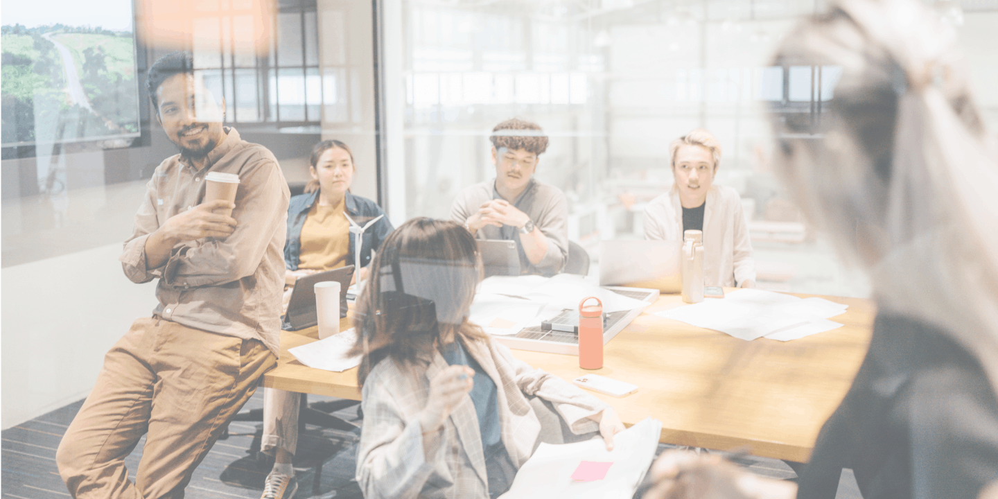 Entspanntes internes Sicherheitsteam, das in einem Konferenzraum in einem modernen Büro arbeitet und Kaffee schlürft