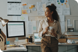 Shot of an attractive young businesswoman standing and looking contemplative while holding a cup of coffee in her home office