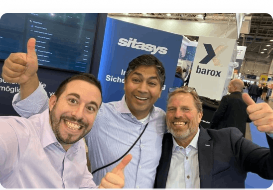 Photo: Boris Stern, Anis Mungapen, and Robbert Vrolijk from Sitasys AG pose smiling, and with thumbs up at the "Security Essen" trade fair