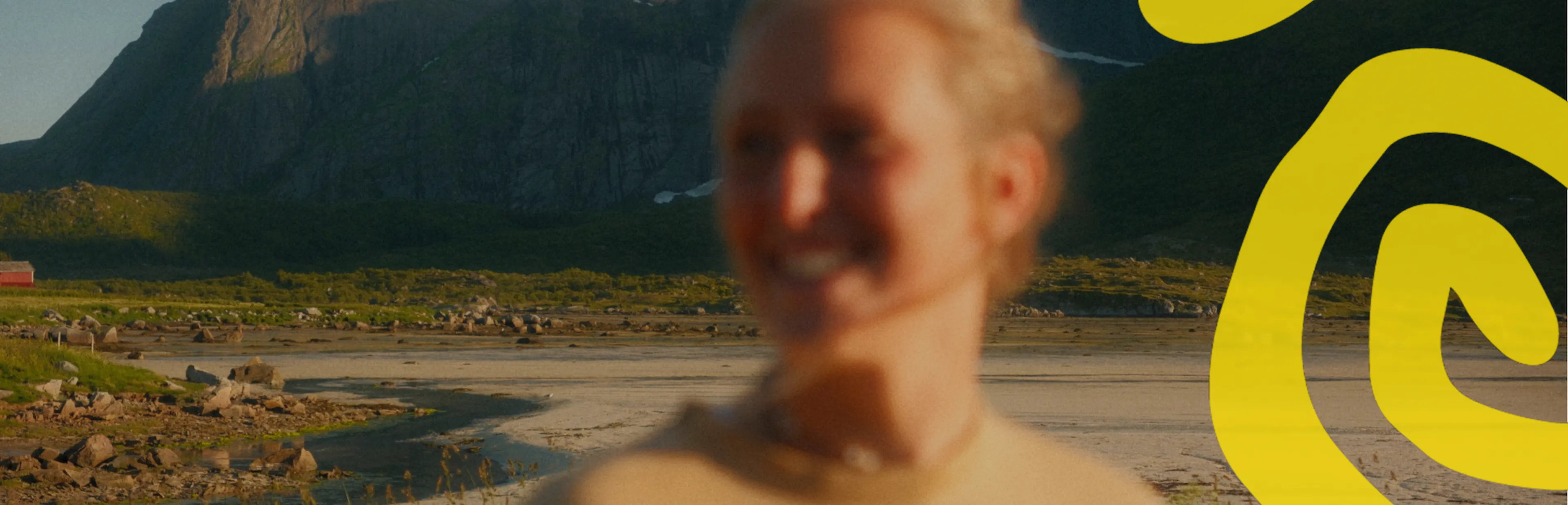 Una mujer sonriente y desenfocada, con montañas al fondo