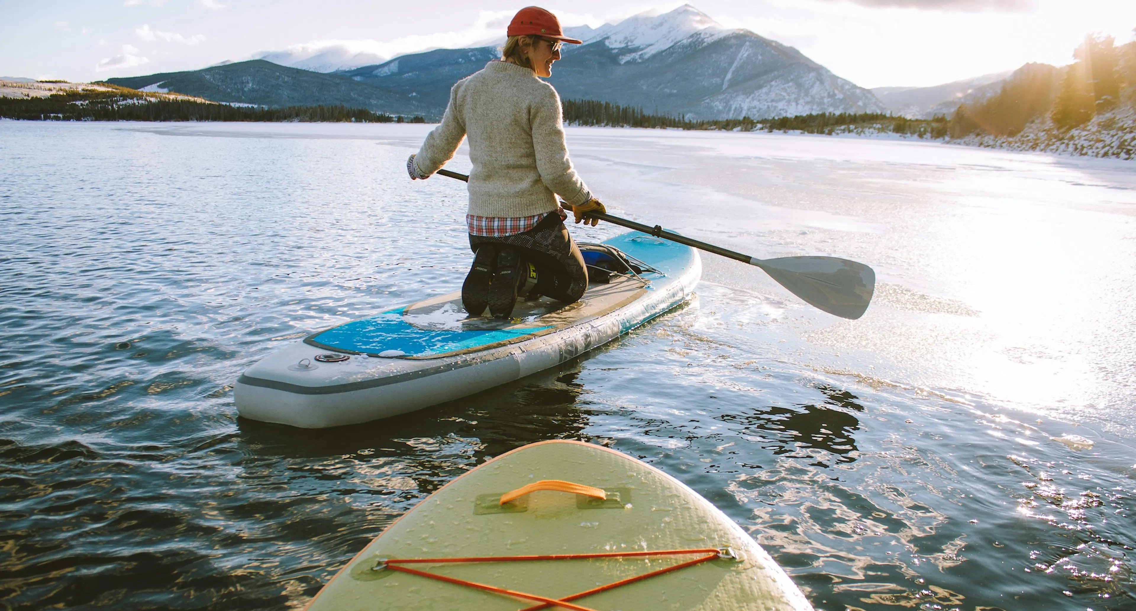 Due persone che praticano il paddle su un lago