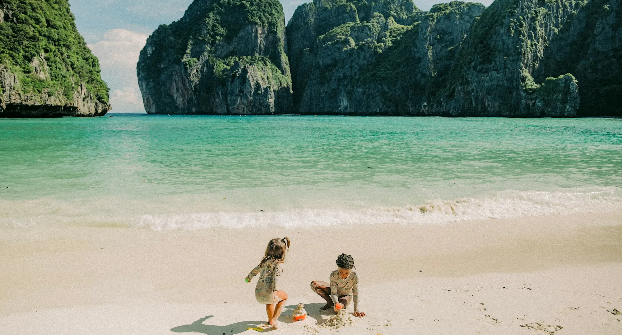 Bambini che giocano sulla spiaggia sotto il sole