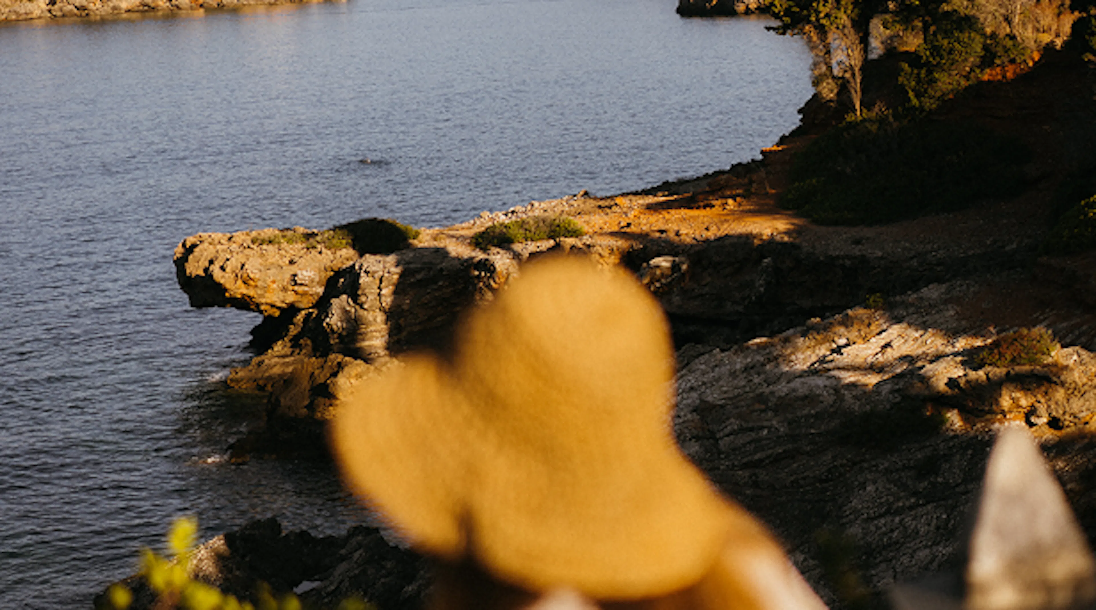 persona con cappello davanti al mare