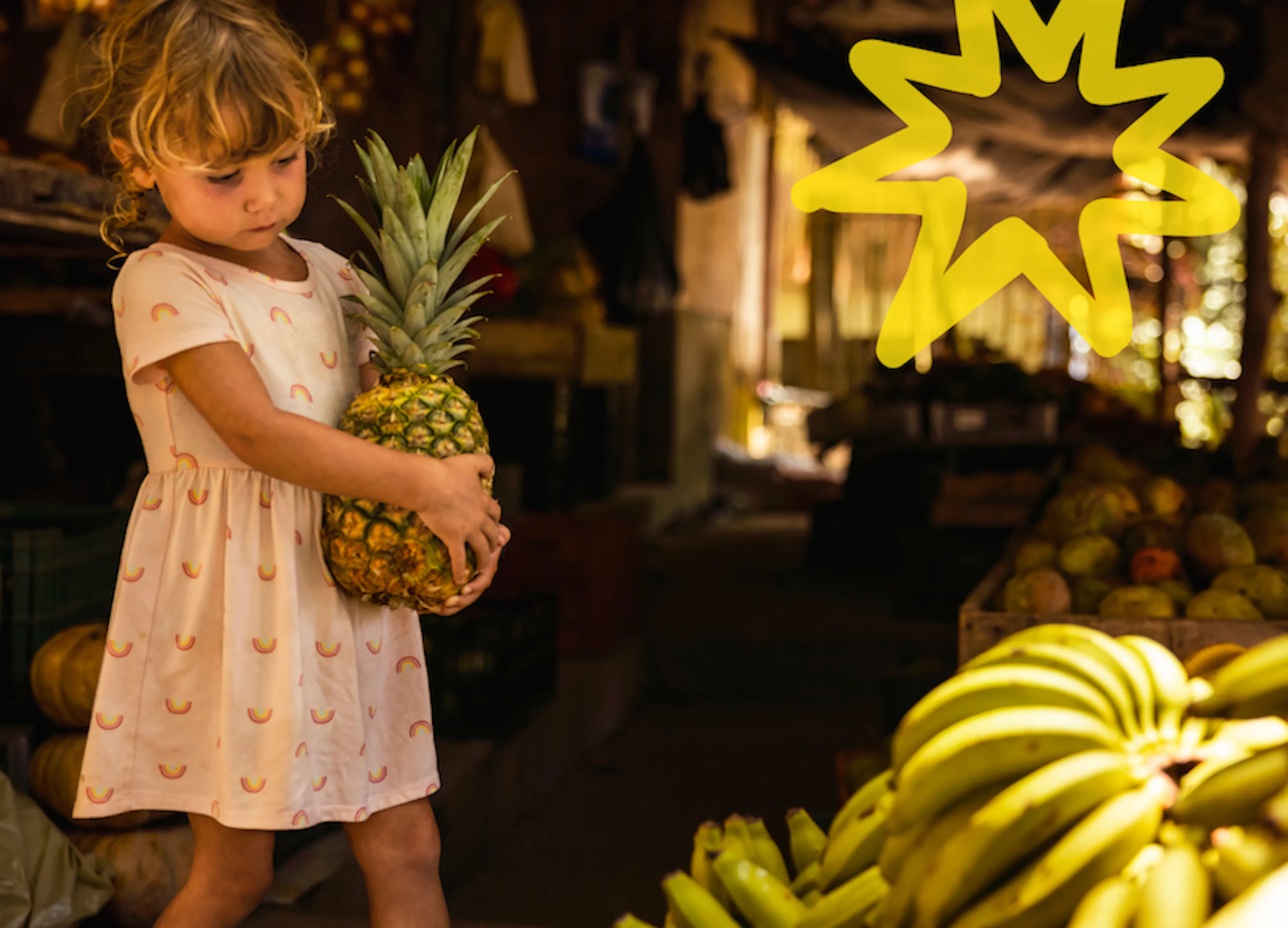 Un niño sosteniendo una piña en un mercado de Costa Rica