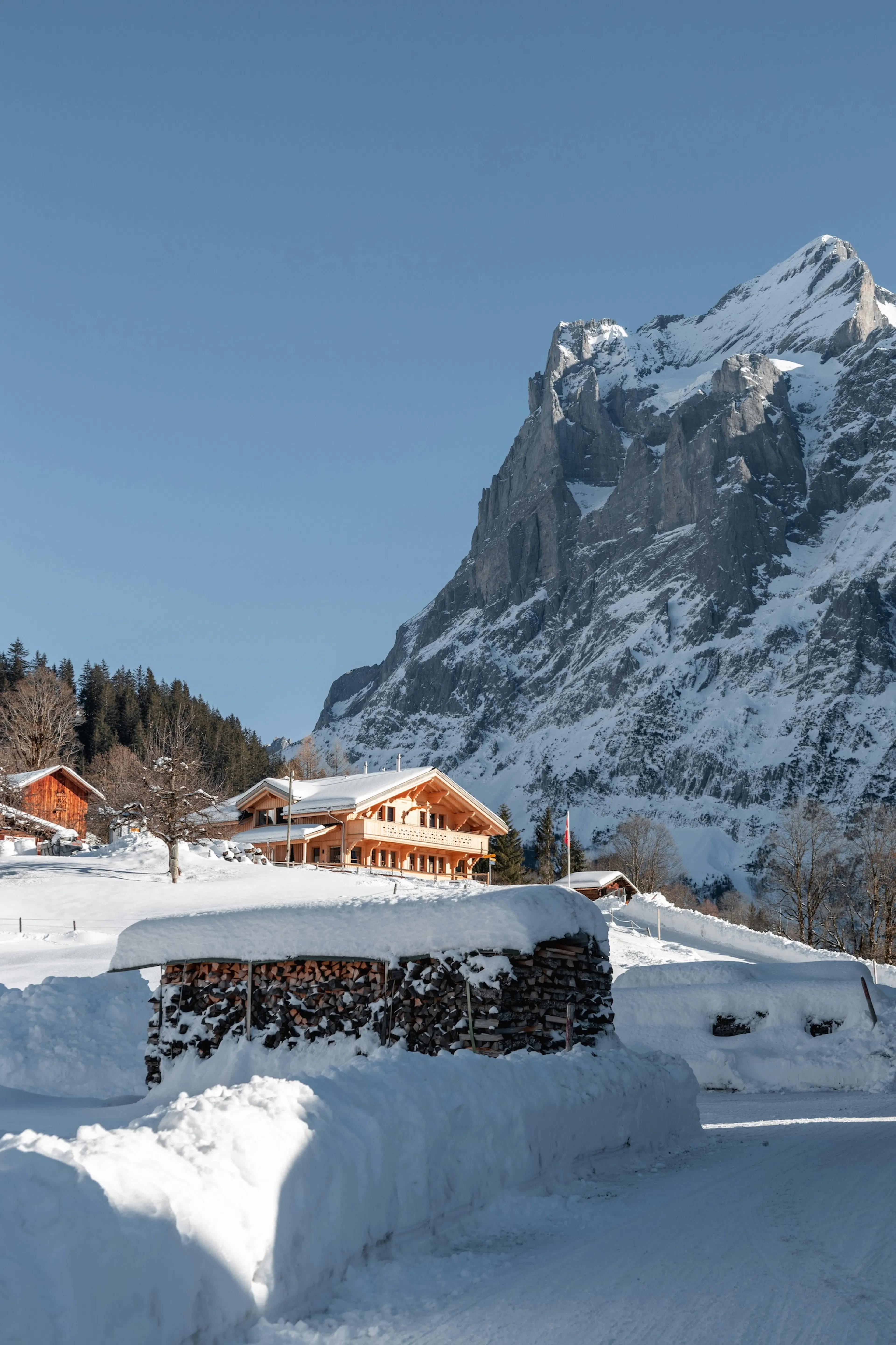 Maison enneigée dans les montagnes autrichiennes, avec un sommet en arrière-plan