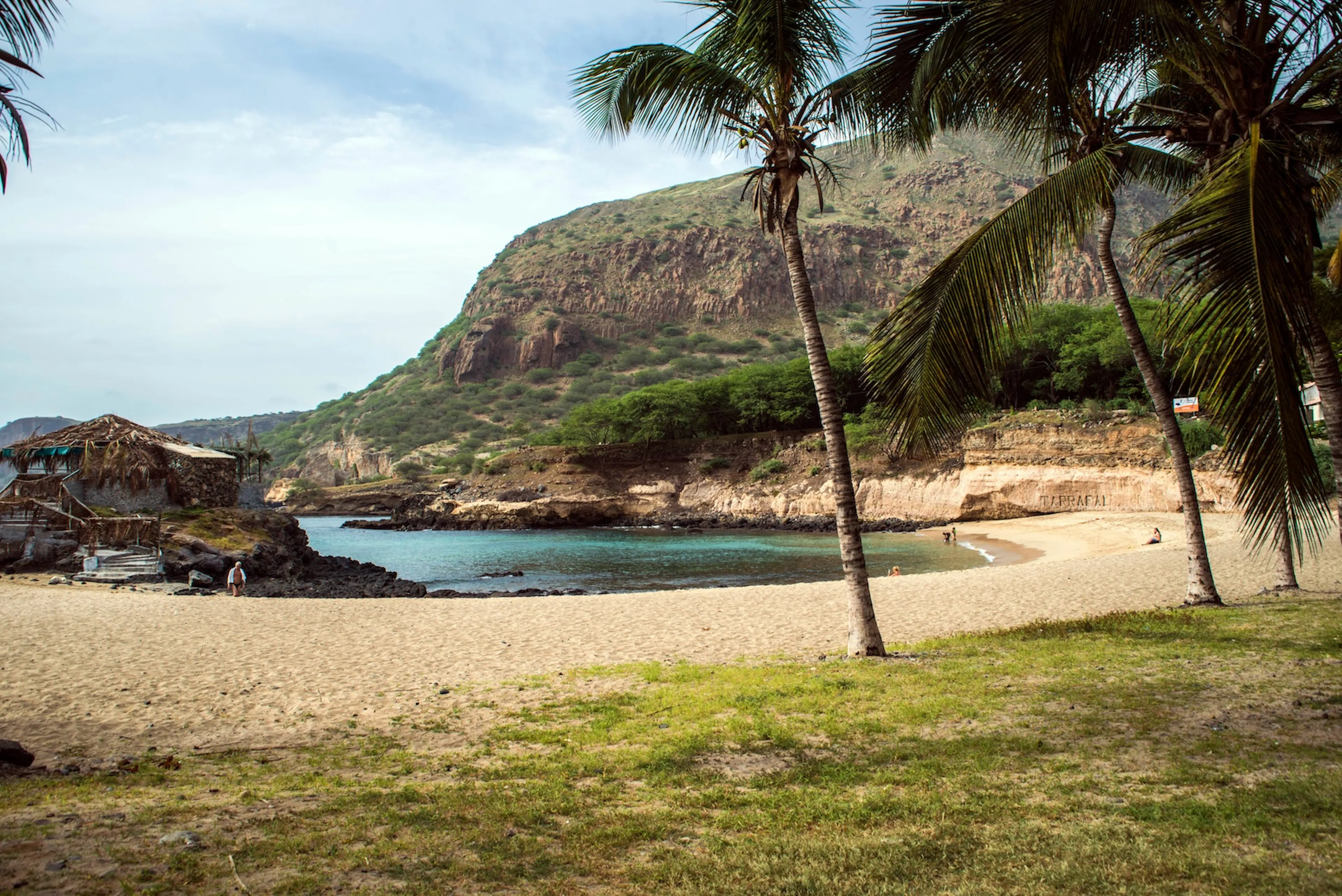 Plage au Cap-Vert avec des montagnes, des palmiers et des eaux cristallines