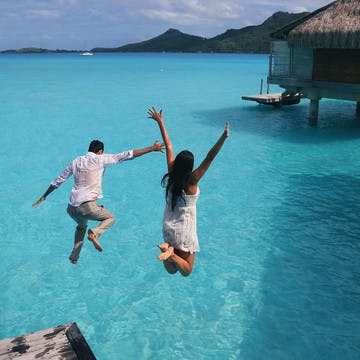 Couple sautant dans un lagon
