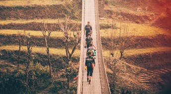 Groupe de marcheurs sur un pont suspendu au Népal