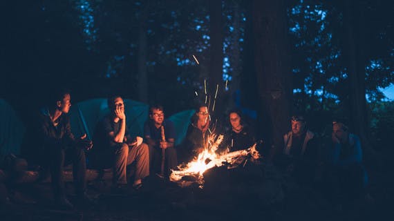 Groupe de voyageurs en bivouac autour d'un feu de camp
