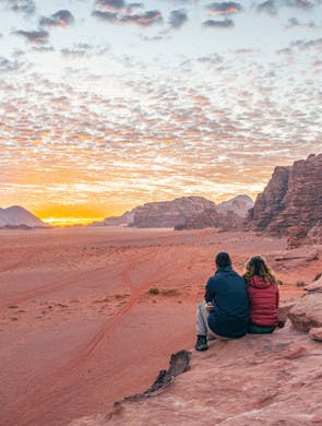 Couple admirant le coucher du soleil dans le Wadi Rum