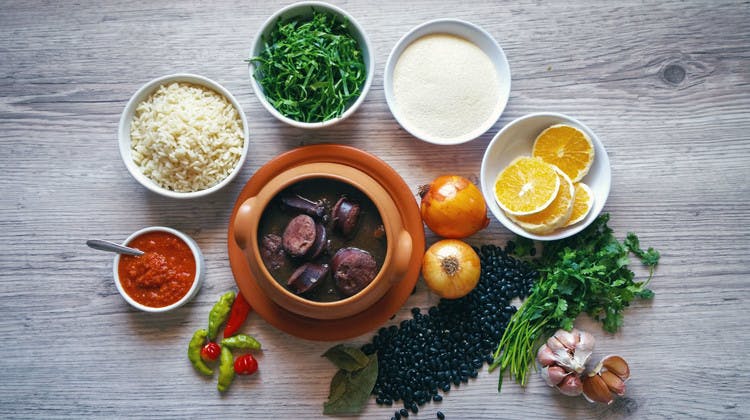 Une marmite de feijoada entourée de ses accompagnements