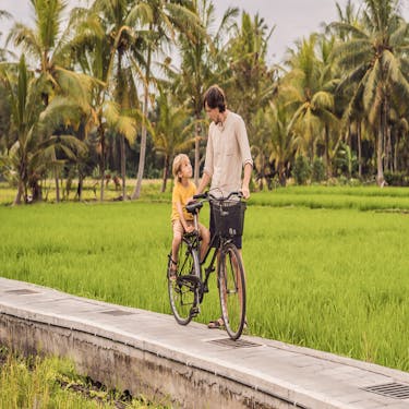 Das Bild zeigt eine Vater mit Kind auf einem Fahrrad