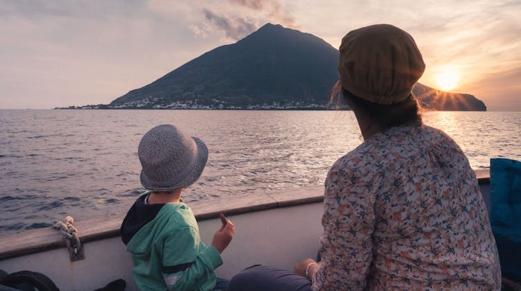 Une femme et son enfant face au volcan de Stromboli