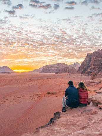 Couple admirant le coucher du soleil dans le Wadi Rum