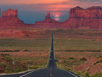 Ruta a través de Monument Valley con el atardecer al fondo