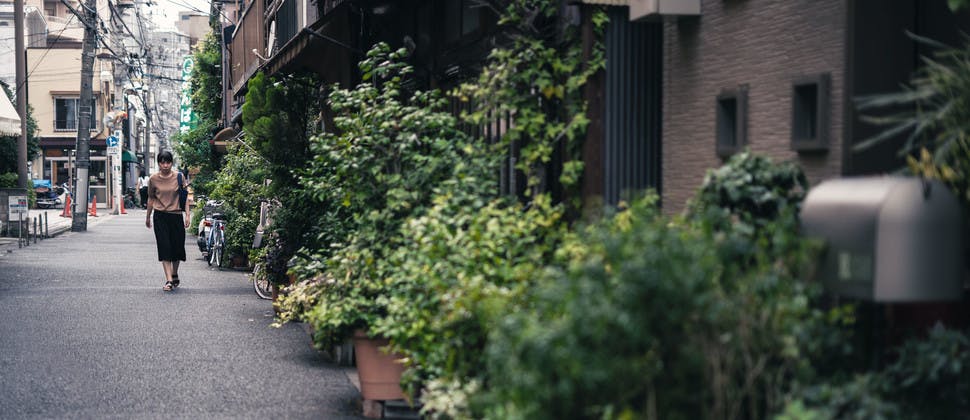 Une femme marchant dans une petite rue de Tokyo