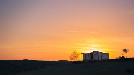 Une tente dans le désert marocain à la tombée de la nuit