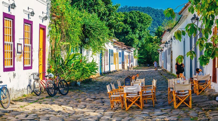Tables d'un restaurant dans une ruelle colorée de Paraty