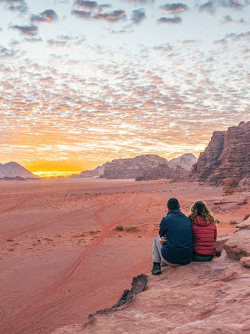 Couple admirant le coucher du soleil dans le Wadi Rum