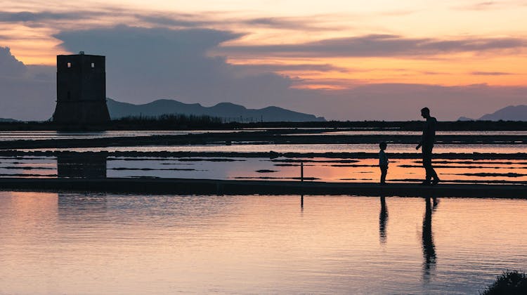 Un homme et son enfant devant les marais salants à Trapani