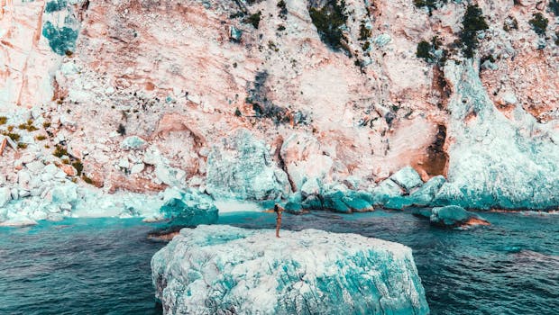 Frau steht auf blauem Felsen vor Sardinien im Golf von Orosei