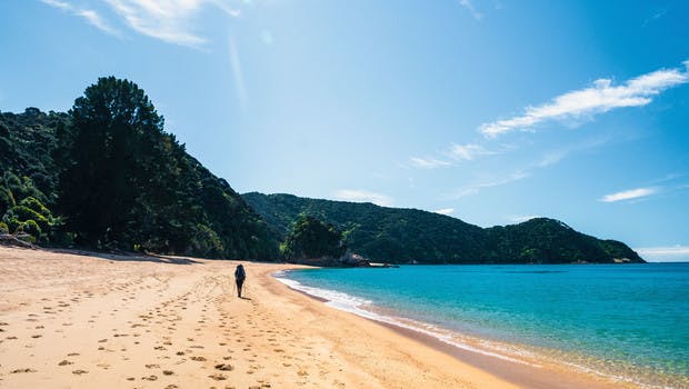 Randonneur sur une plage du parc Abel Tasman en Nouvelle-Zélande