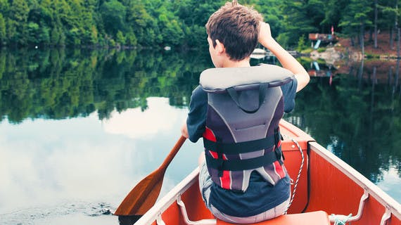 Niño navegando un lago en Canadá