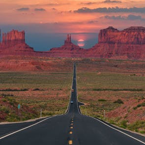 Ruta a través de Monument Valley con el atardecer al fondo