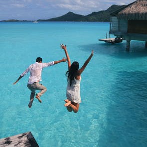 Couple sautant dans un lagon