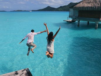 Couple sautant dans un lagon