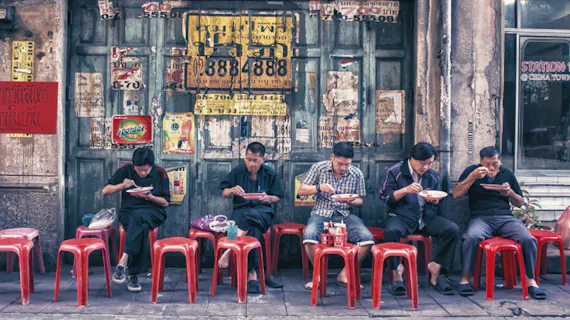 Männer essen in Thailand am Straßenrand