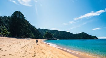 Randonneur sur une plage du parc Abel Tasman en Nouvelle-Zélande