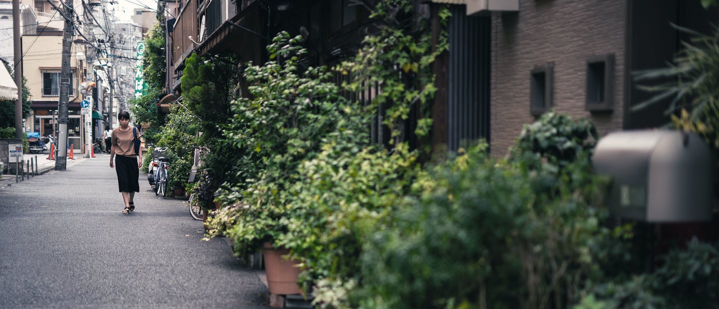 Une femme marchant dans une petite rue de Tokyo