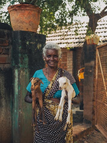 Femme indienne avec des chèvres dans les bras