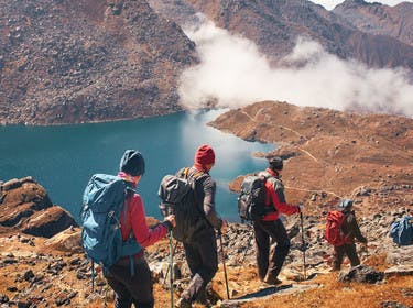 Groupe de randonneurs en montagne se dirigeant vers un lac