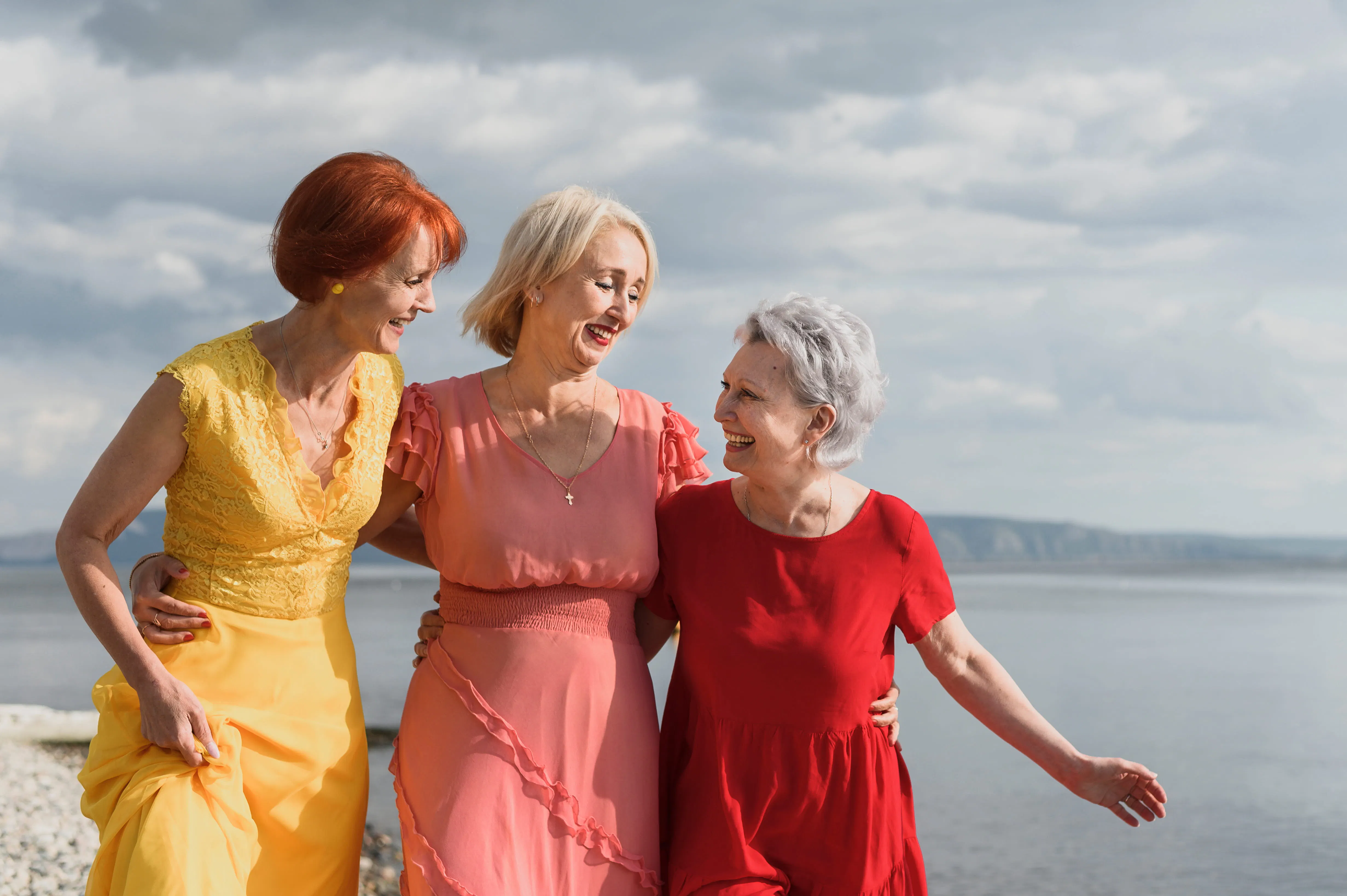Three women linking arms—a symbol of the importance of stable social relationships and emotional well-being during menopause