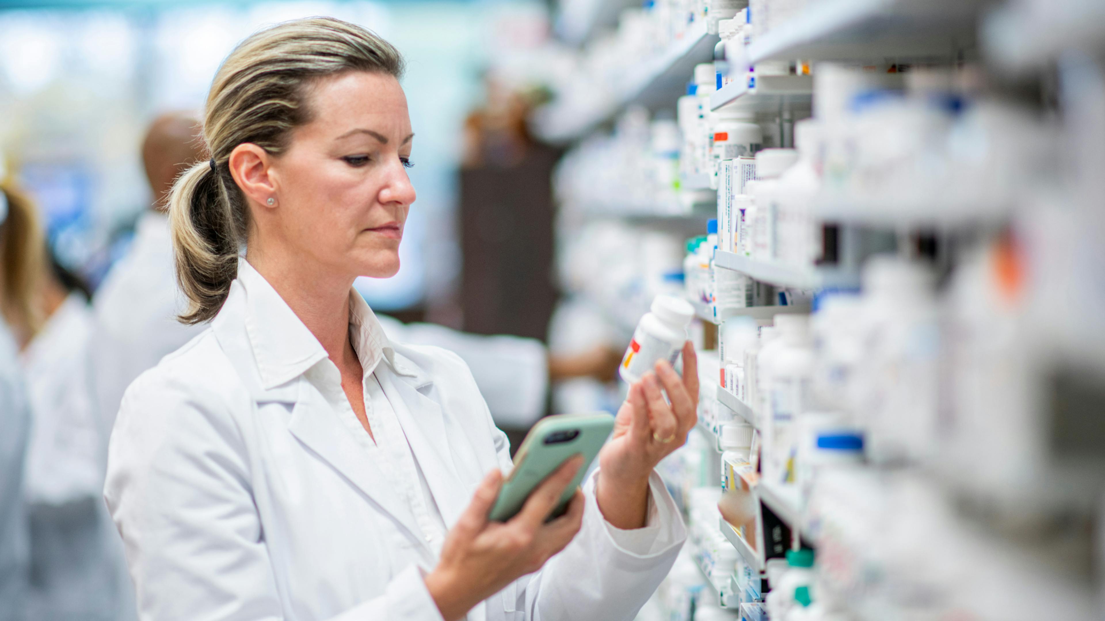 Pharmacist reading medicine's label