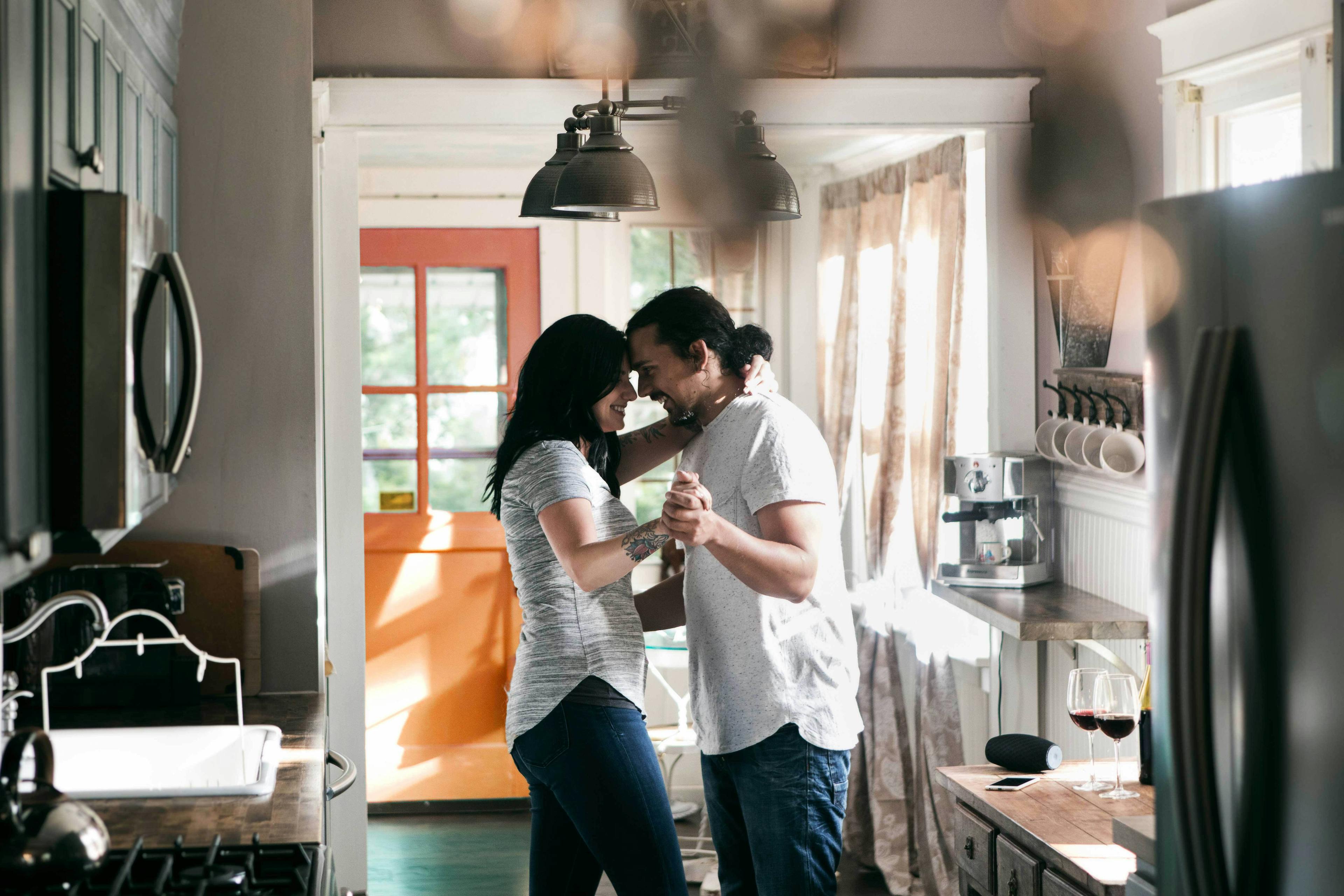 A couple dances together in their kitchen