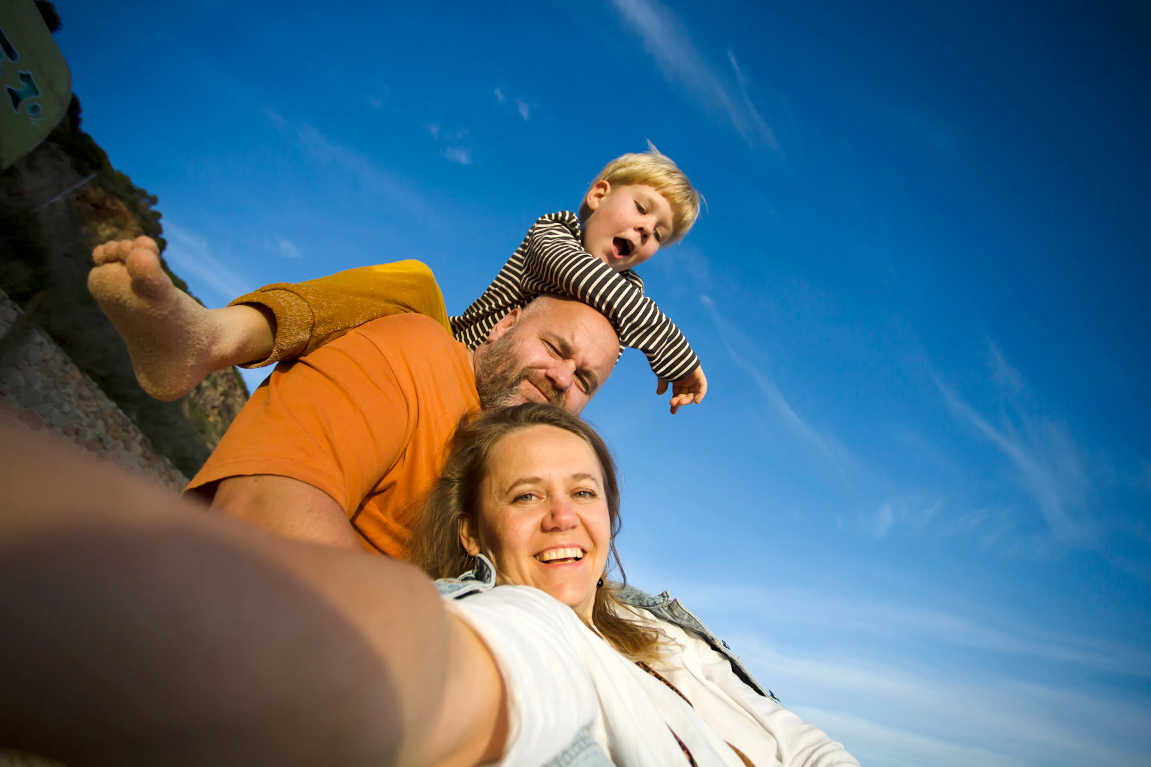 Family of 3 taking a candid photo at the beach