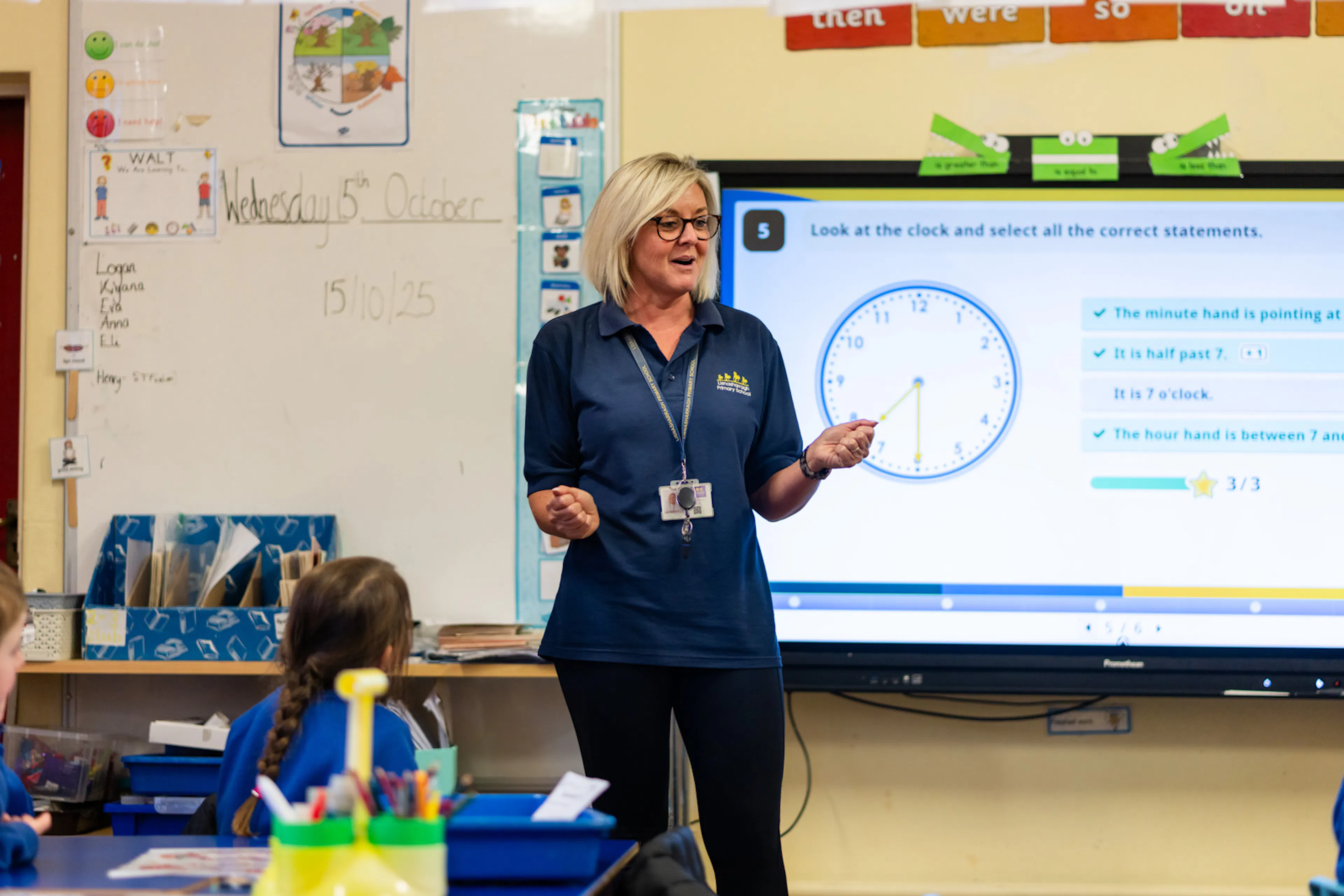 Teacher teaching a lesson in front of an interactive whiteboard