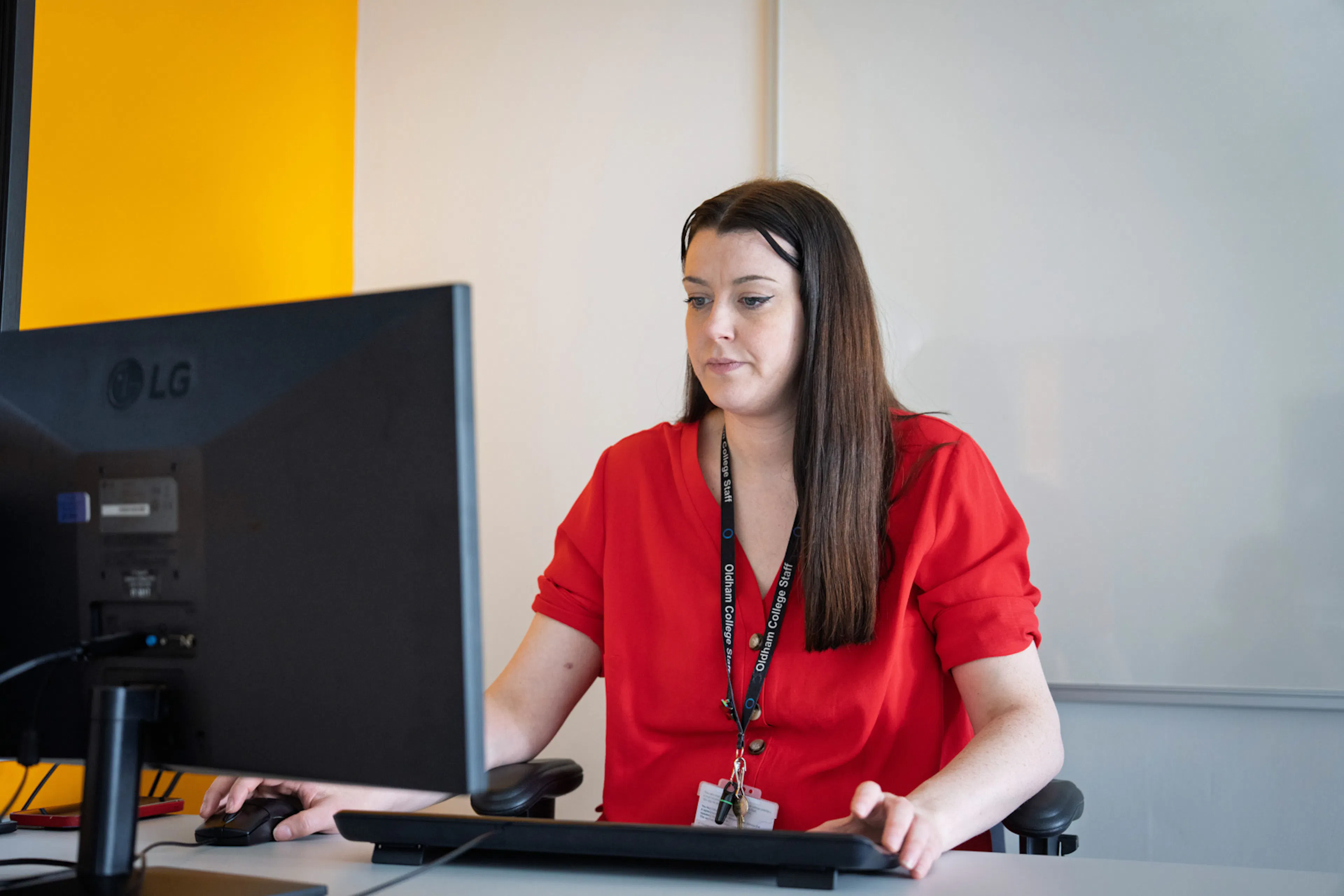 Educator sitting at a desk working on a computer