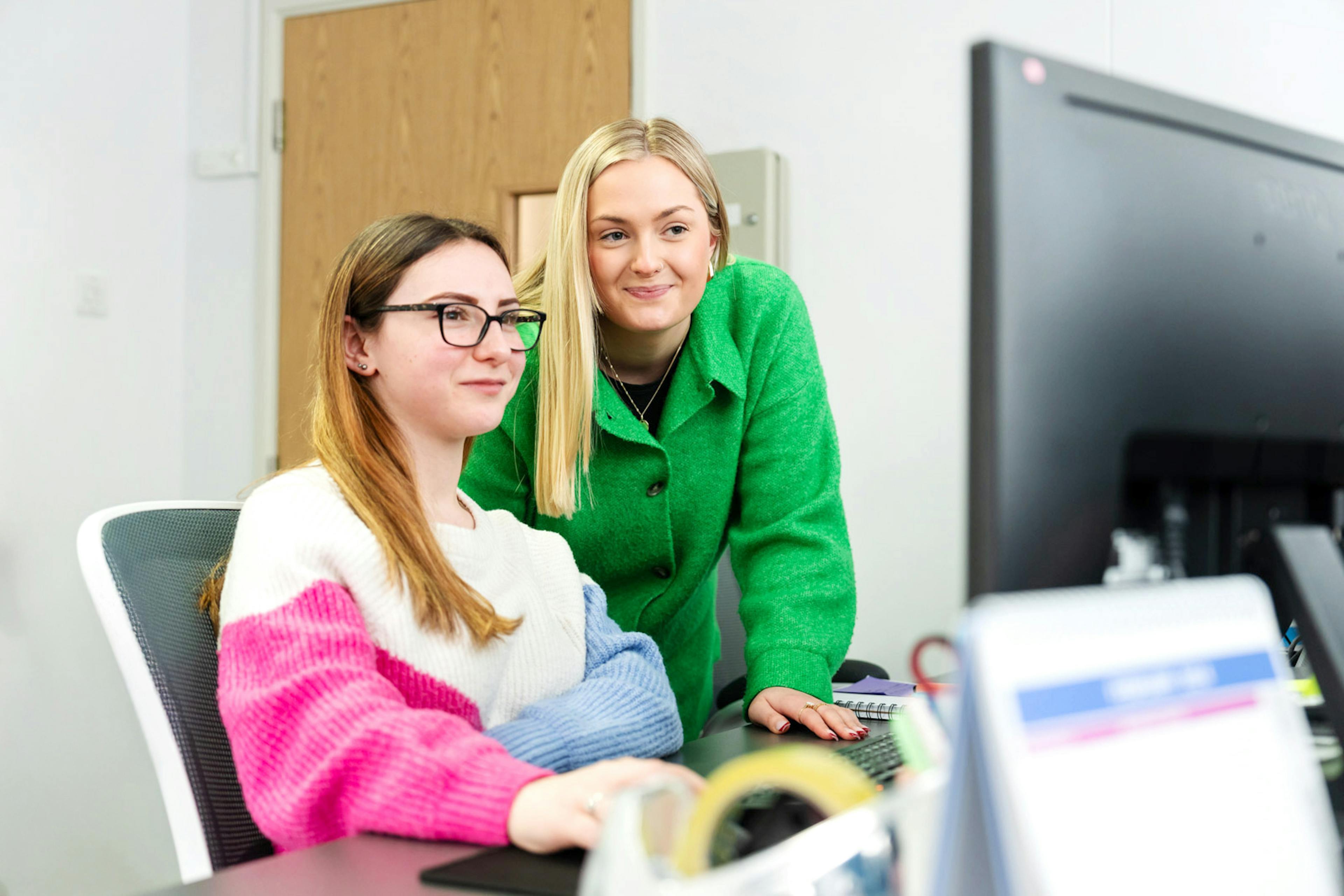 Employees working together on a computer