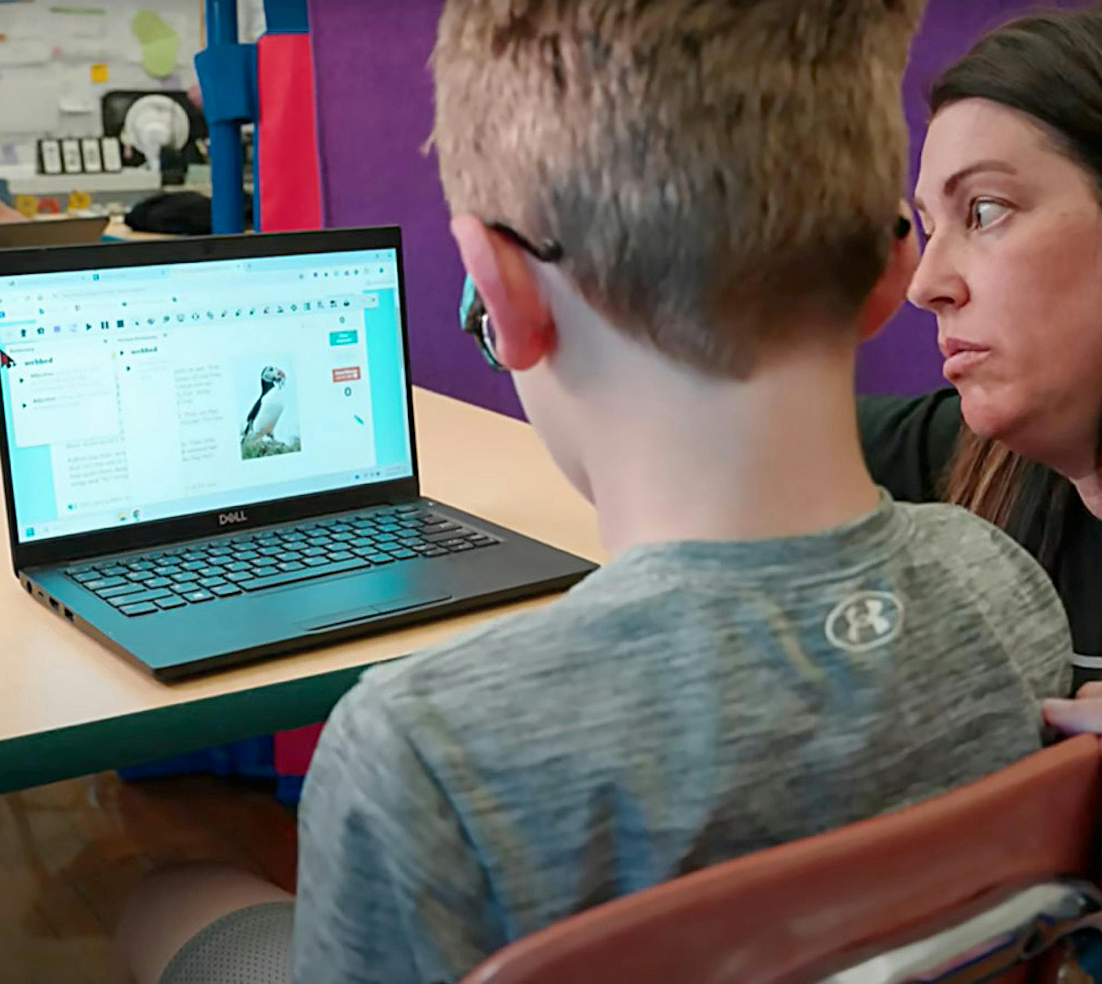 A teacher is helping a student use Read&Write on a laptop