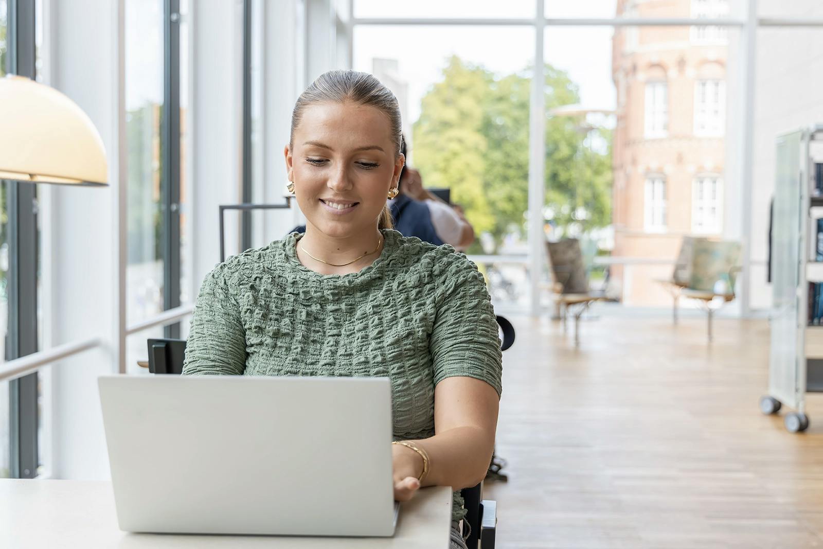 student som använder en dator i ett bibliotek