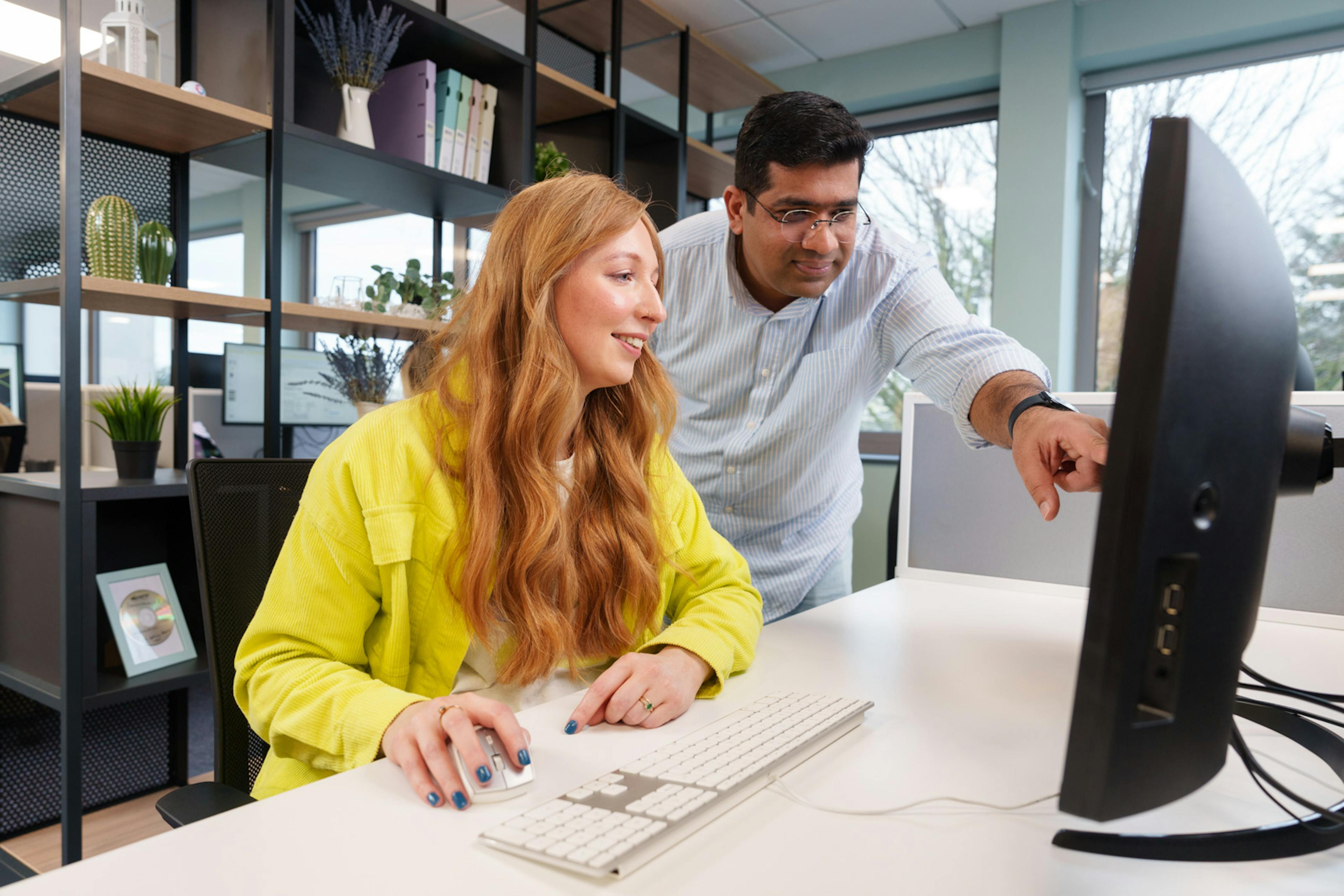 2 employees working at a computer 