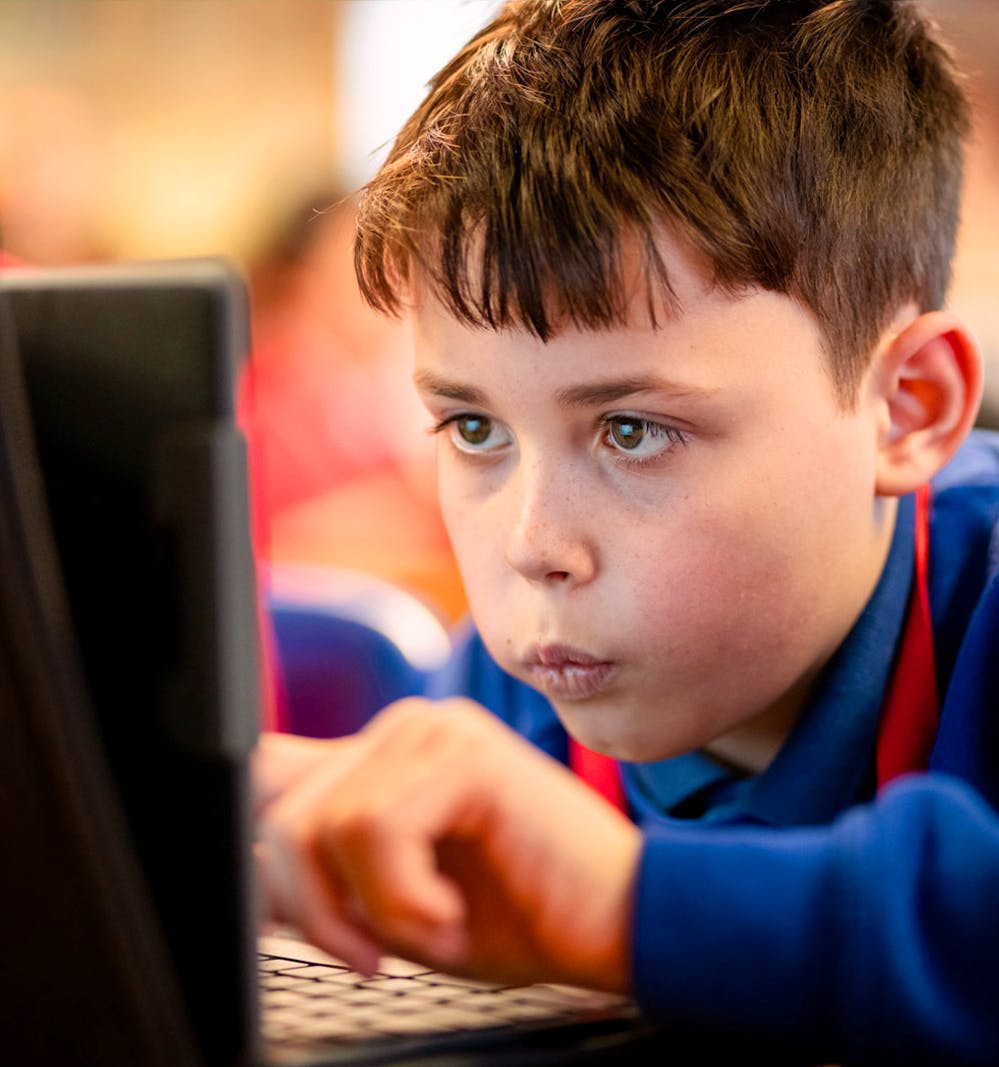 A close up of a student working on a laptop