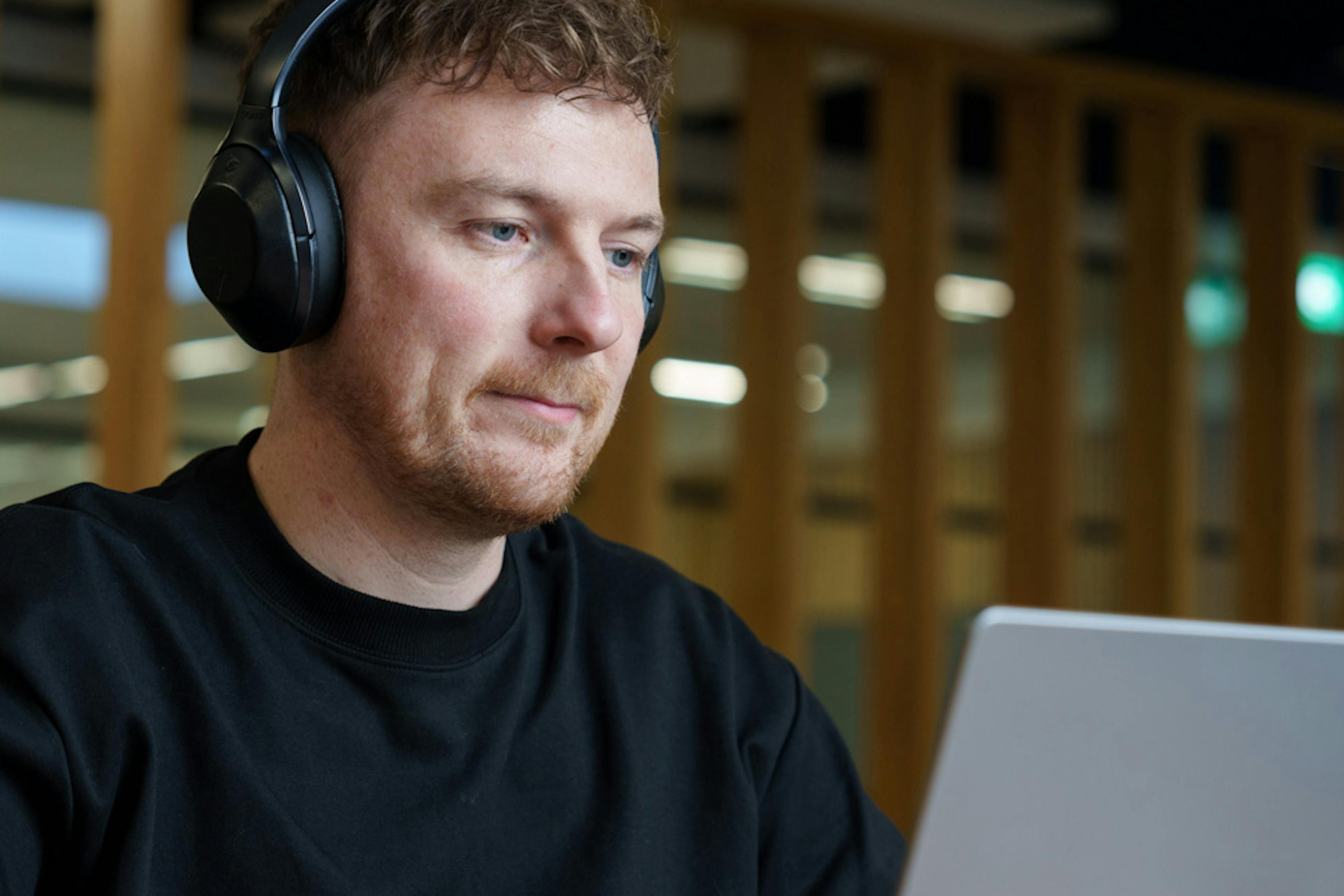 An Everway team member using a laptop with headphones on