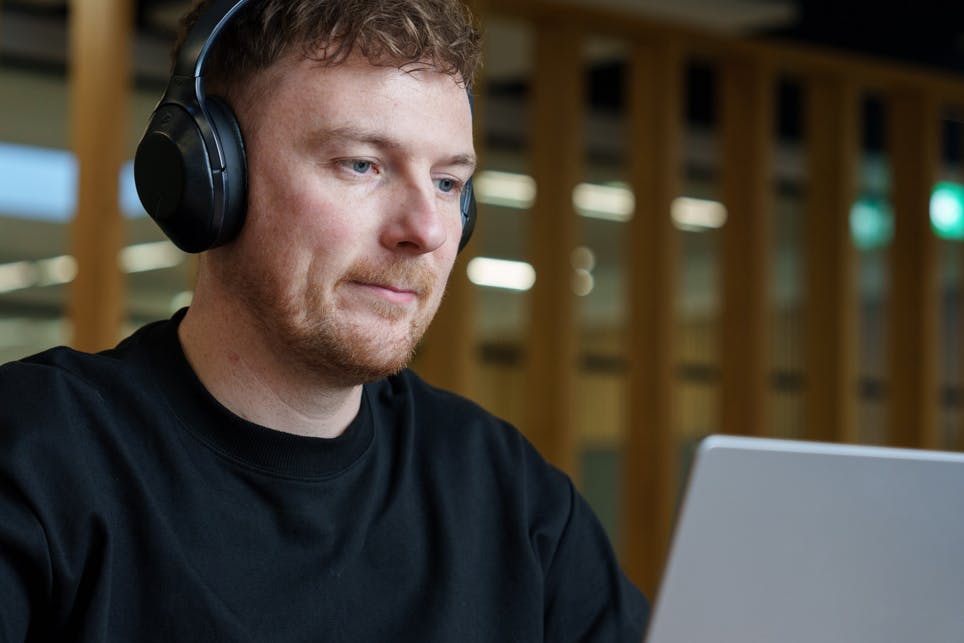 An Everway team member using a laptop with headphones on