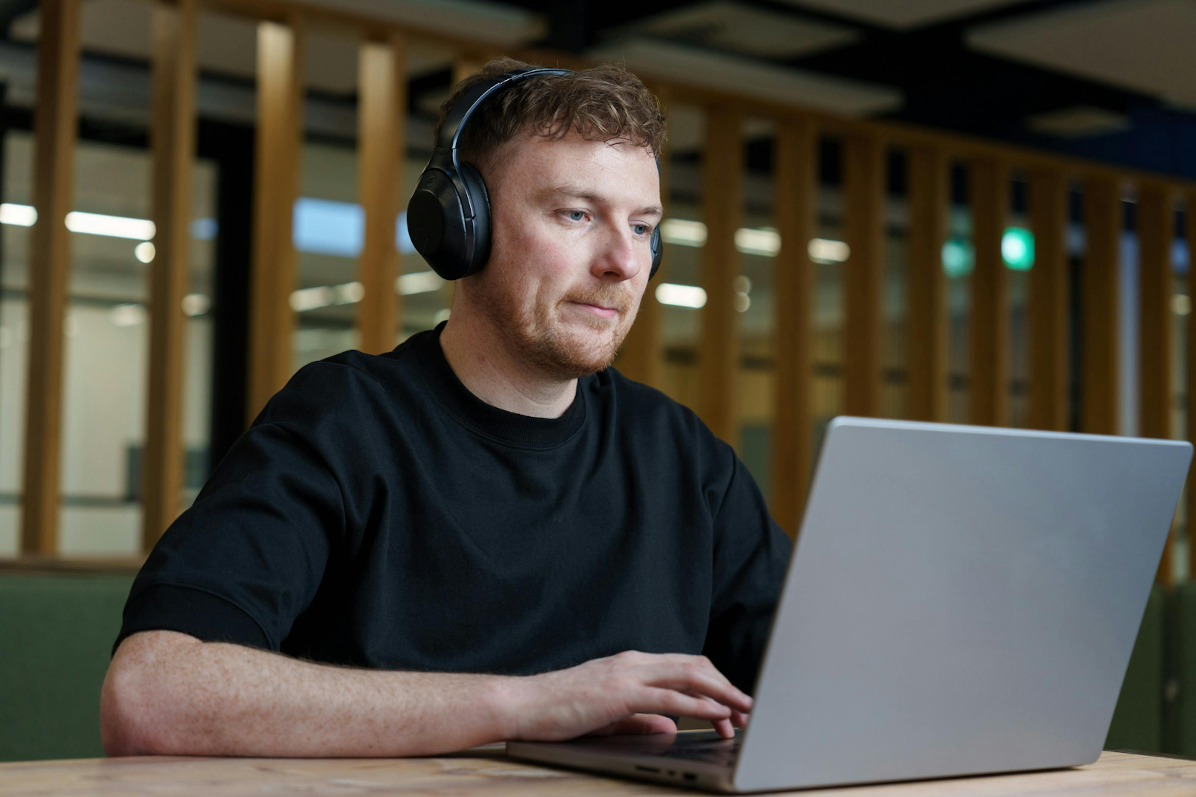 An Everway team member using a laptop with headphones on