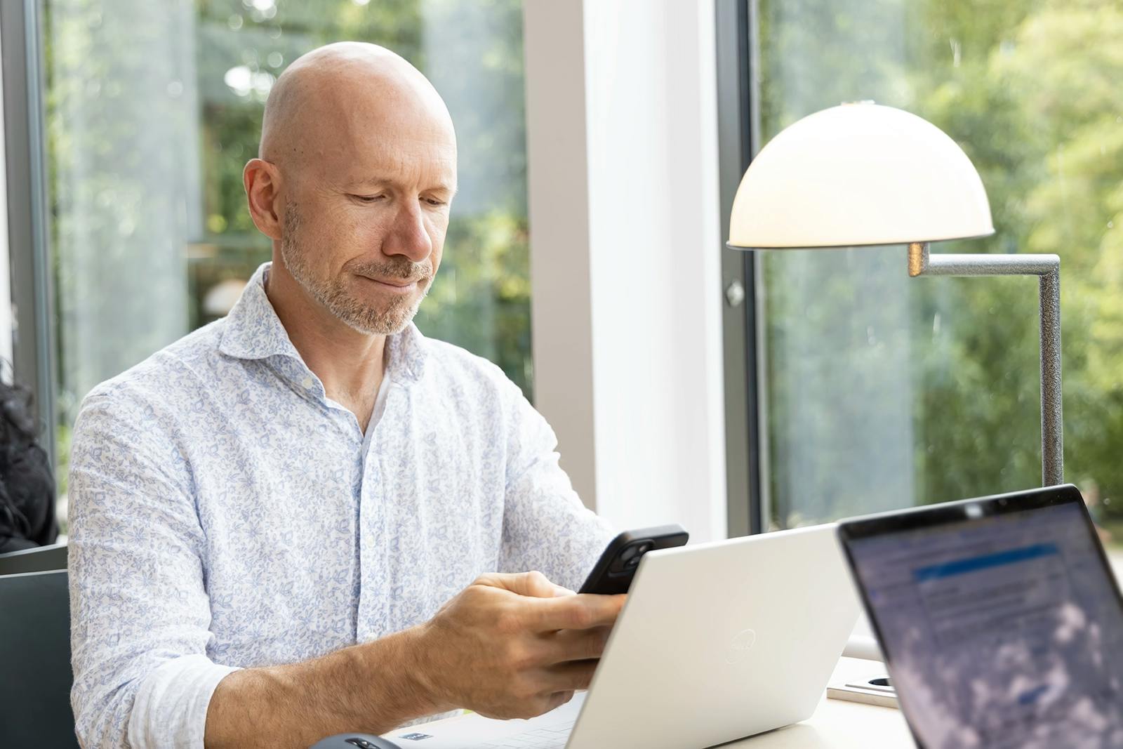 A person  using a laptop and a phone